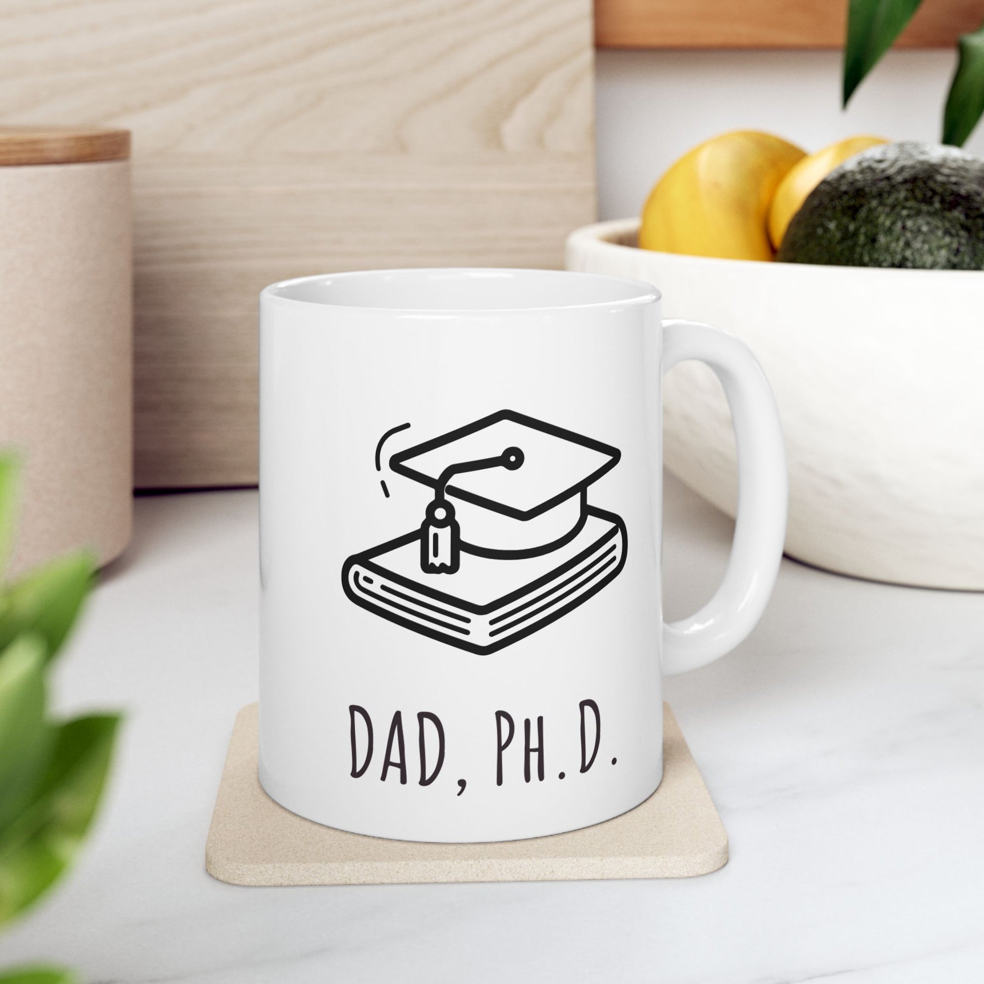 White mug with 'DAD, PH.D.' design on a coaster with a wooden background