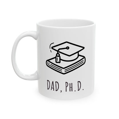 White mug with a graduation cap and books design and 'Dad, Ph.D.' text on a white background